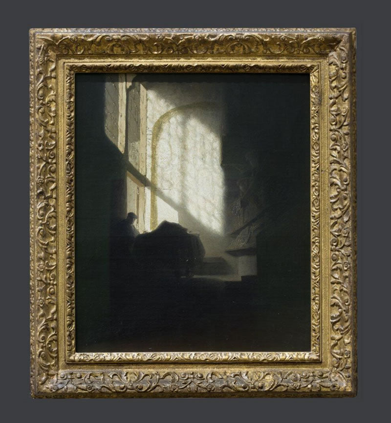 A Man seated reading at a Table in a Lofty Room