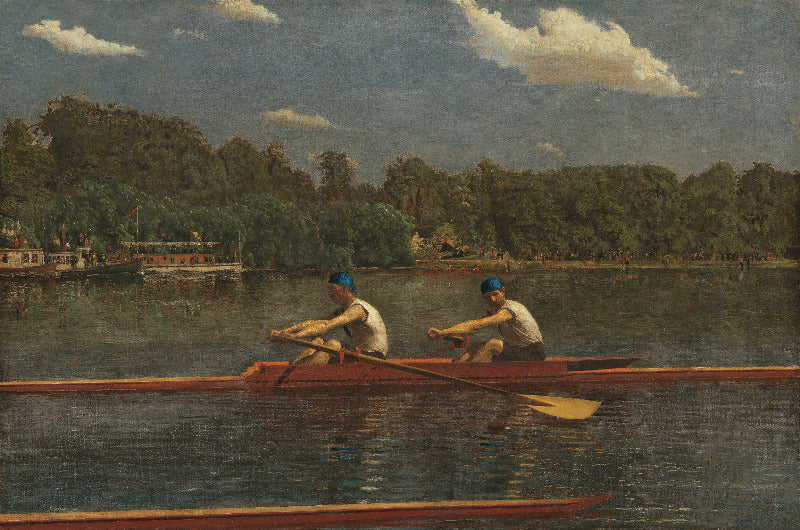 Two rowers in a boat on a lake with trees and buildings in the background
